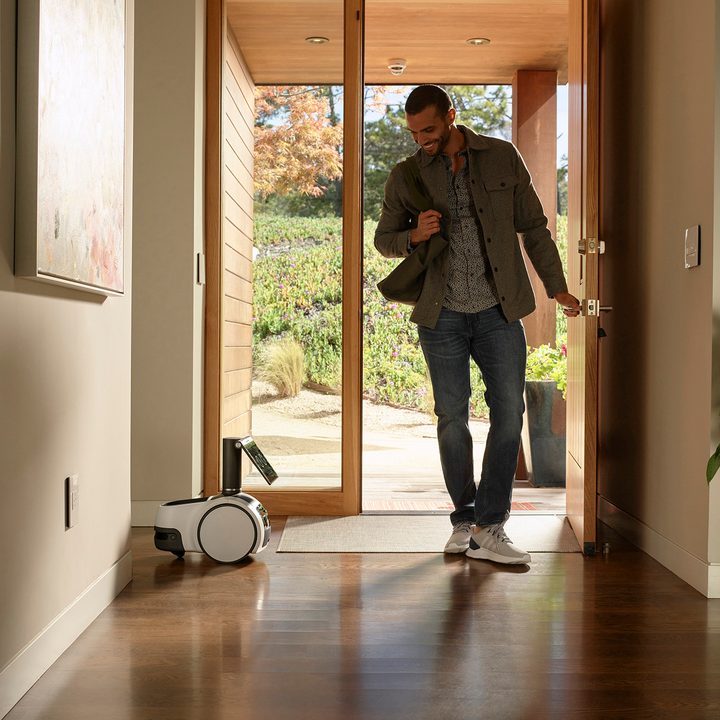 Amazon Astro greeting a guy walking through front door.