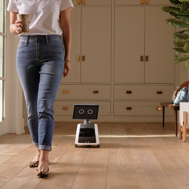 Astro robot follows behind woman.