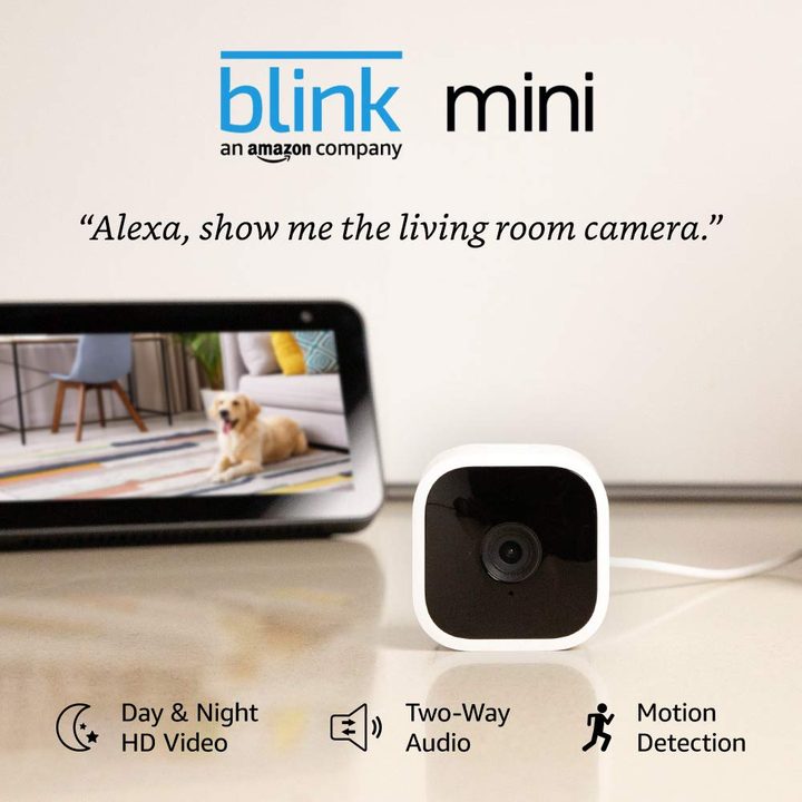 Blink Mini compact indoor smart security camera and phone screen showing living room.