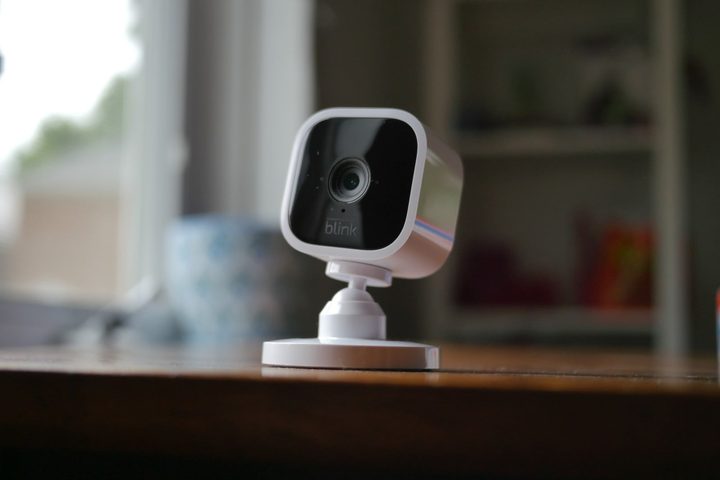 blink mini indoor camera white set in a living room blurred in the background