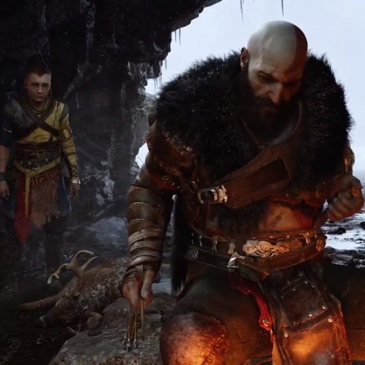 Kratos and his son sit by a fire in God of War Ragnarok.