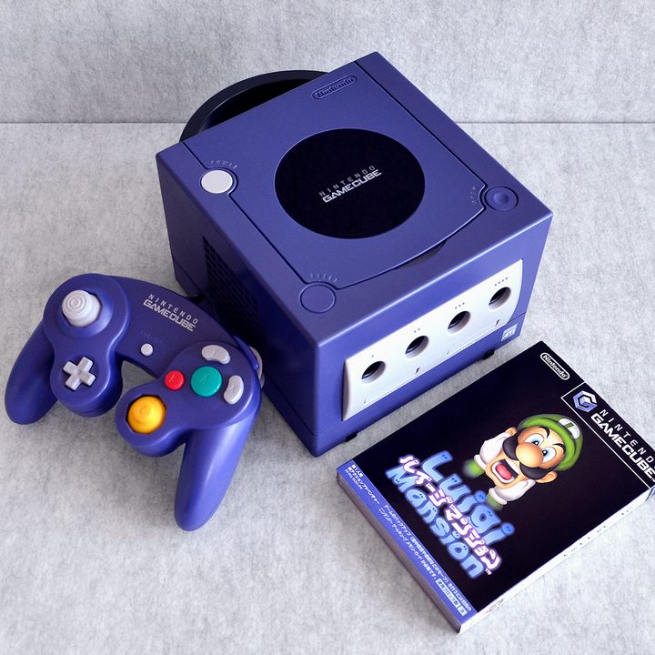 A Nintendo GameCube sits on a table with Luigi's Mansion.