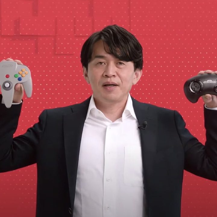 A Nintendo executive holds up the new Switch N64 and Sega Genesis controllers.