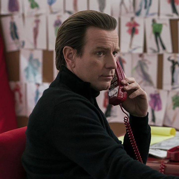 Ewan McGregor sitting at a desk on the phone in a scene from Halston.