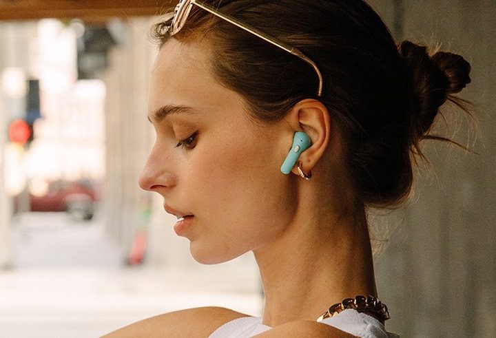 Woman wearing Happy Plugs Hope earbuds.