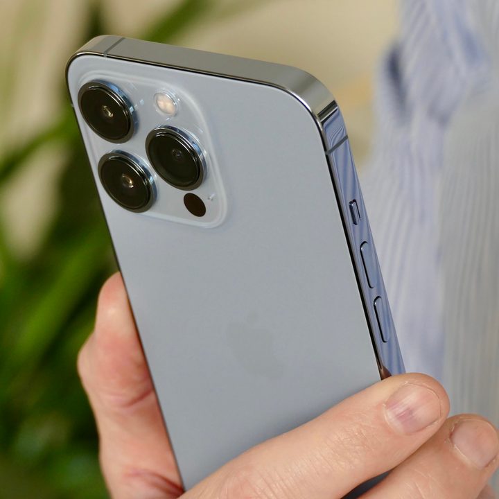iPhone 13 Pro's camera module seen from the back, held in hand.