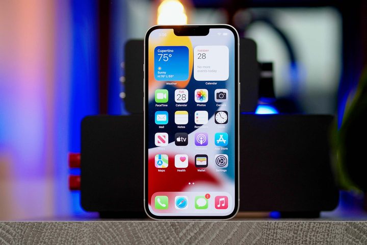 An Apple iPhone 13 showing the home screen apps and widgets.