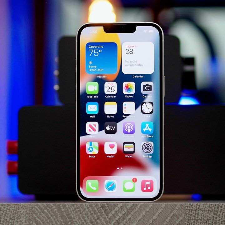 An Apple iPhone 13 showing the home screen apps and widgets.