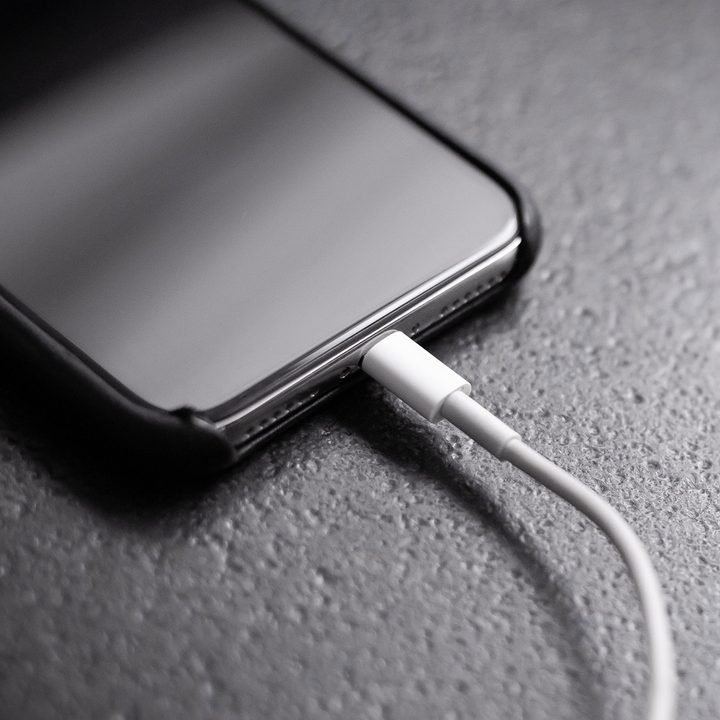 Black iPhone 11 plugged into charger.