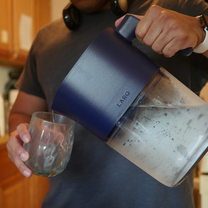 Pouring water into glass from Larq PureVis water pitcher.