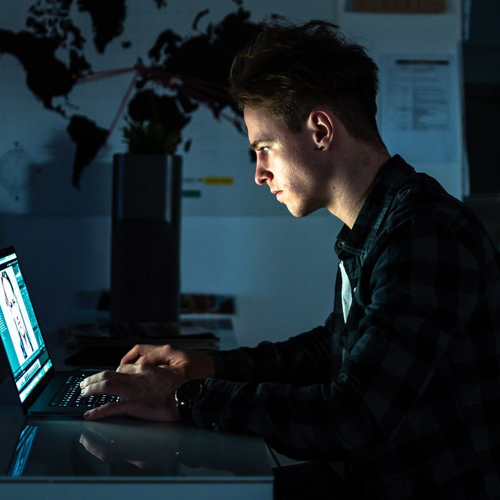 Man using a Macbook Pro at a desk.
