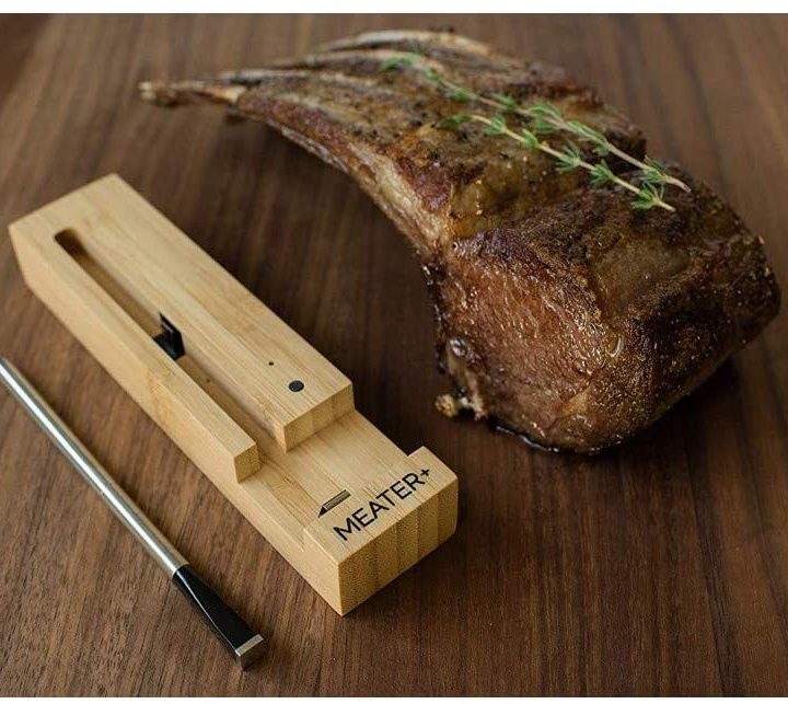 The Meater thermometer next to cooked ribs on a table.