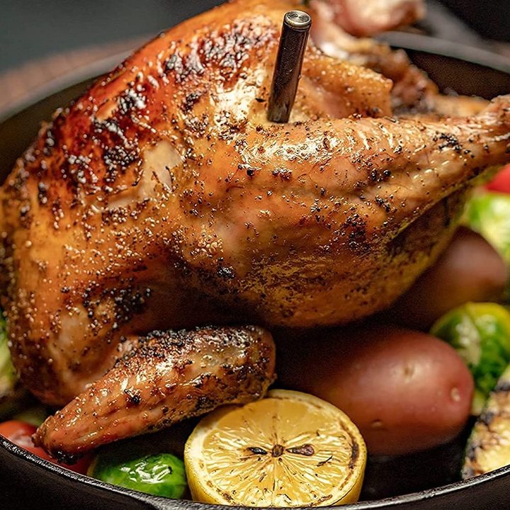 The MeatStick thermometer inside a cooked chicken in a pan.