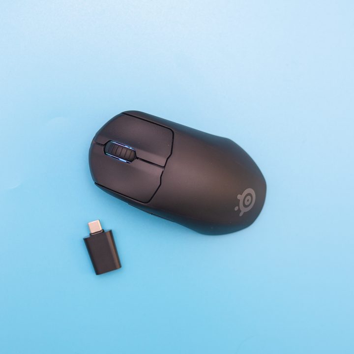 The SteelSeries Prime Mini and dongle on a blue background.