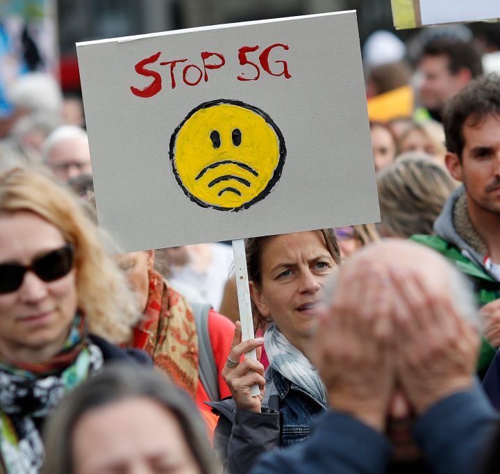 an anti-5G protestor holing a sign