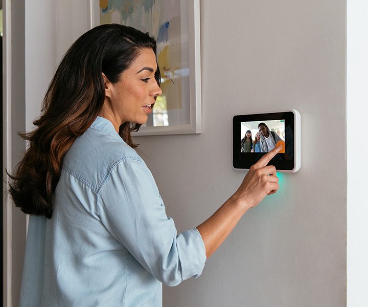 Woman using Vivint's display hub to view live security video.