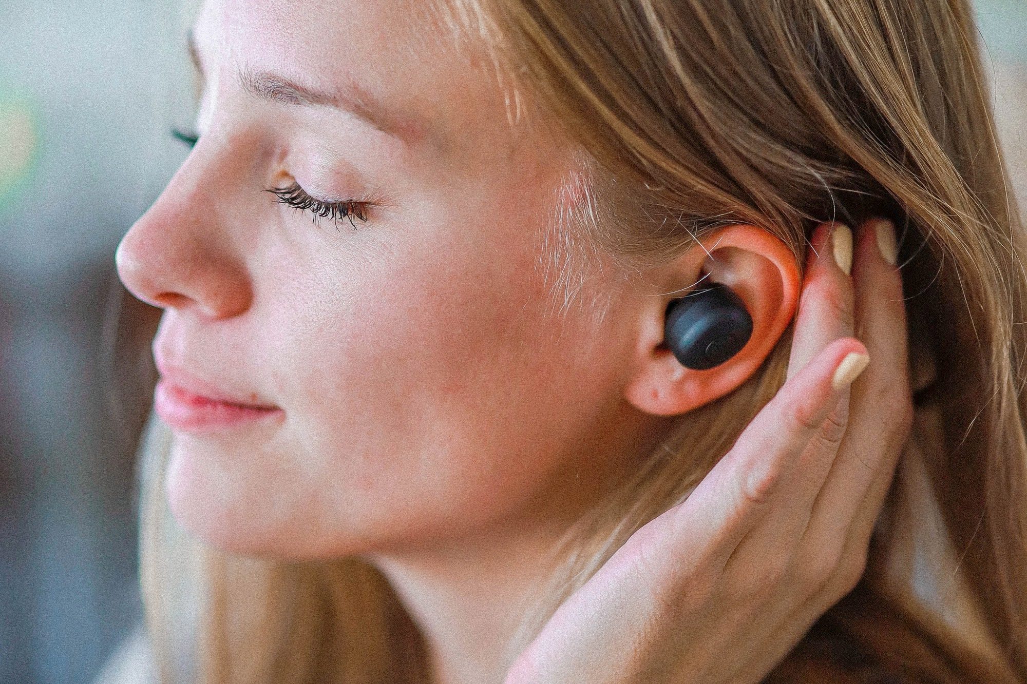 Woman wearing Yamaha's TW-E3B true wireless earbuds.
