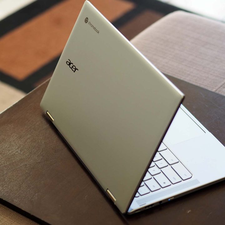 An Acer Chromebook Spin 514 sitting on a table (backside view).