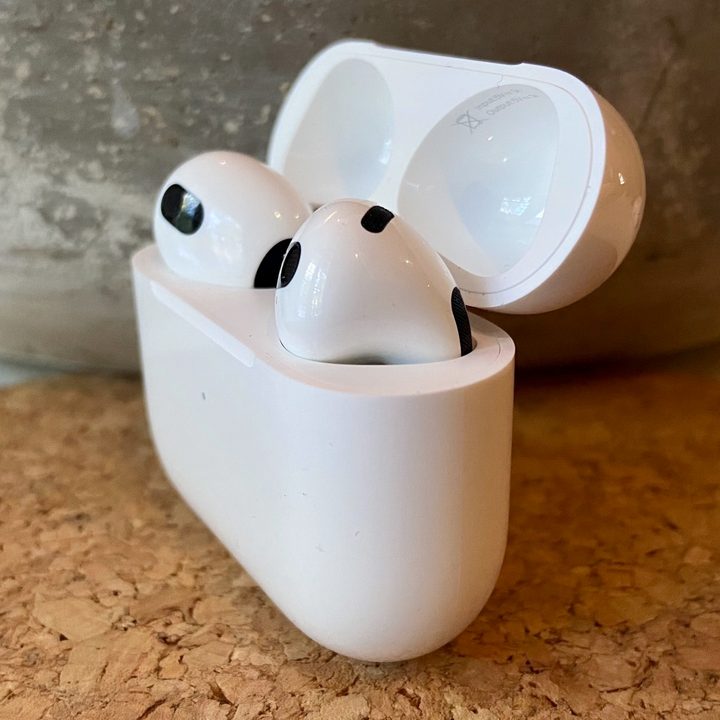 Apple AirPods 3 sit in their charging case.