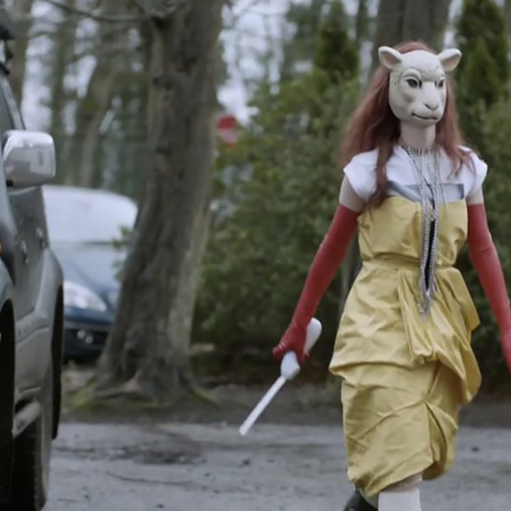 A woman with a mask chasing down a player in the White Bear episode of Black Mirror.