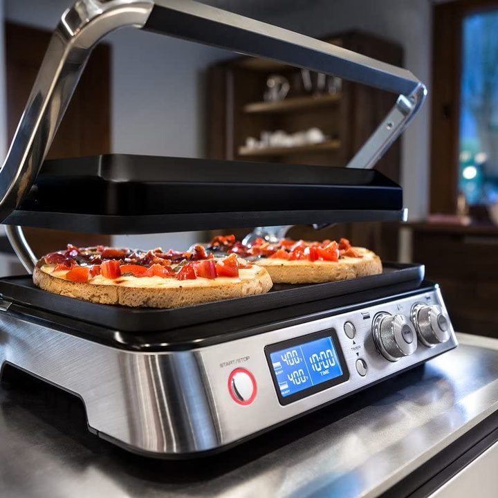 The De'Longhi Livenza All Day Grill on a kitchen counter in a panini mode.