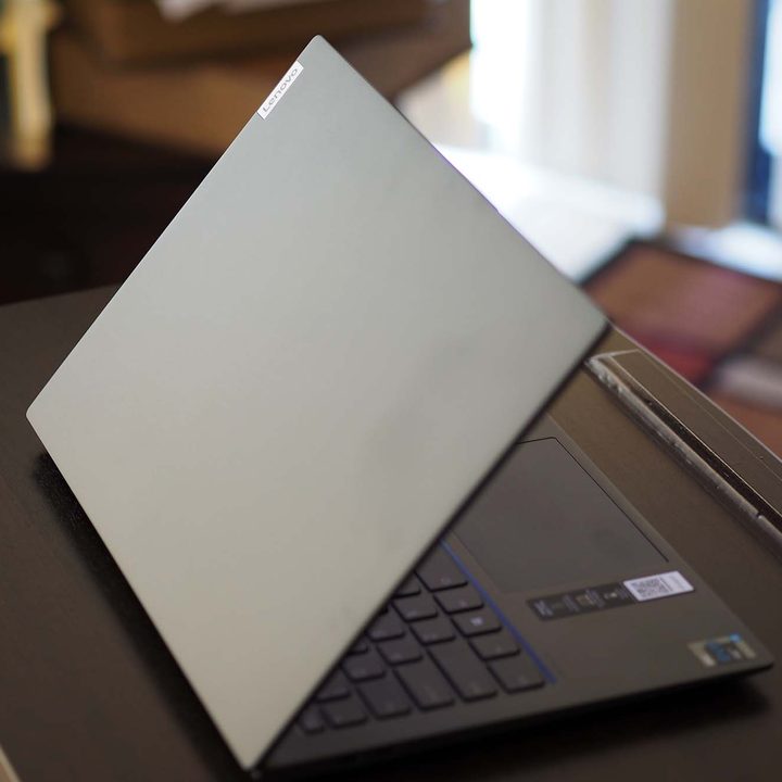A Lenovo IdeaPad Slim 7i Pro sitting on a table, angled to a view of the backside and lid.
