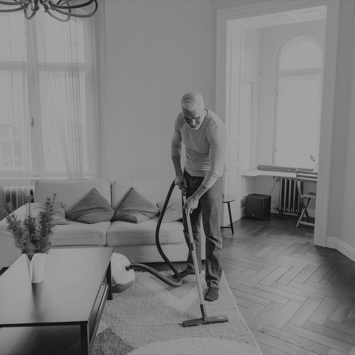 man using vacuum on rug