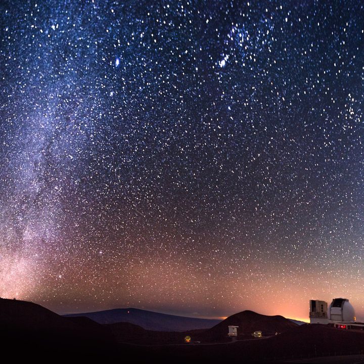 The summit of Maunakea, Hawai'i at night, showing the two Keck telescope domes in the front right.