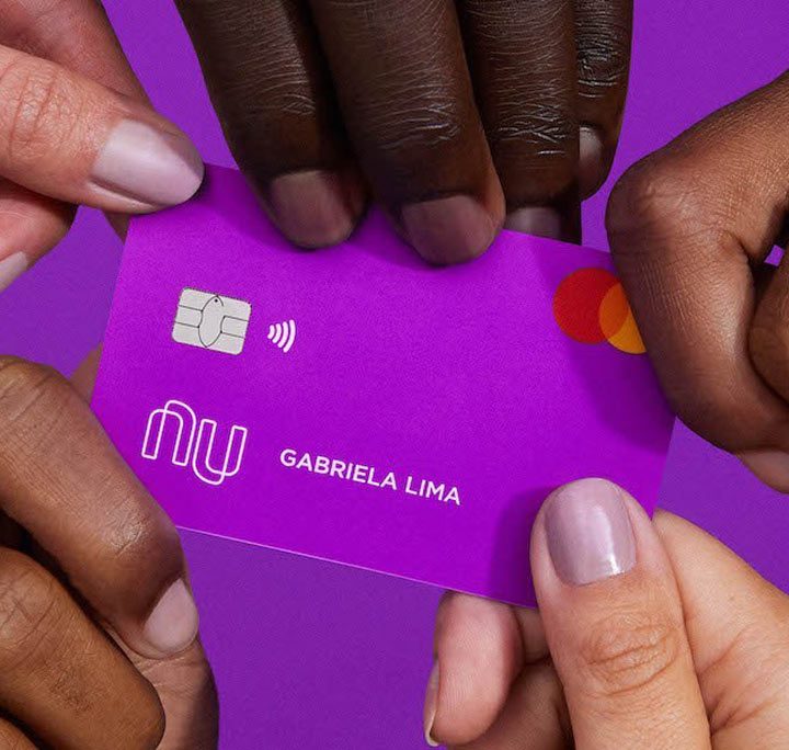 Hands holding a Nubank card.