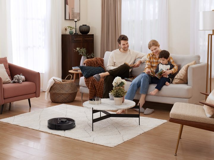 Family in living room with Roborock S7 cleaning.