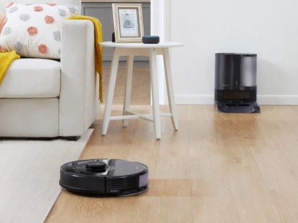 Roborock S7+ cleaning floor with autodock in background.