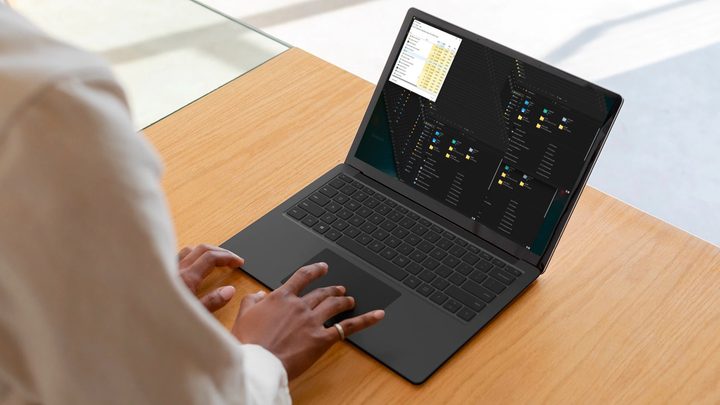 A person using a laptop that is running Windows 11.