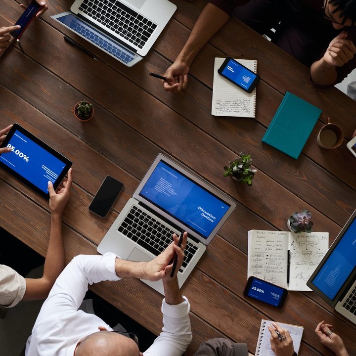 Team using unified communications around work desk at a collab session.
