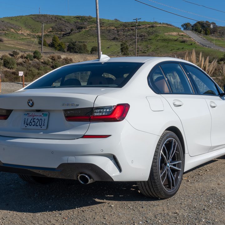 BMW 330e next to road sitting on dirt
