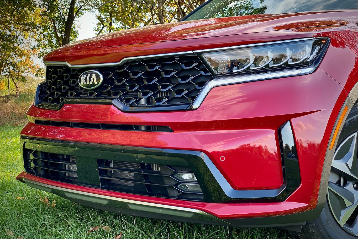 Close up of the front end of the 2021 Kia Sorento Hybrid in a grassy field.