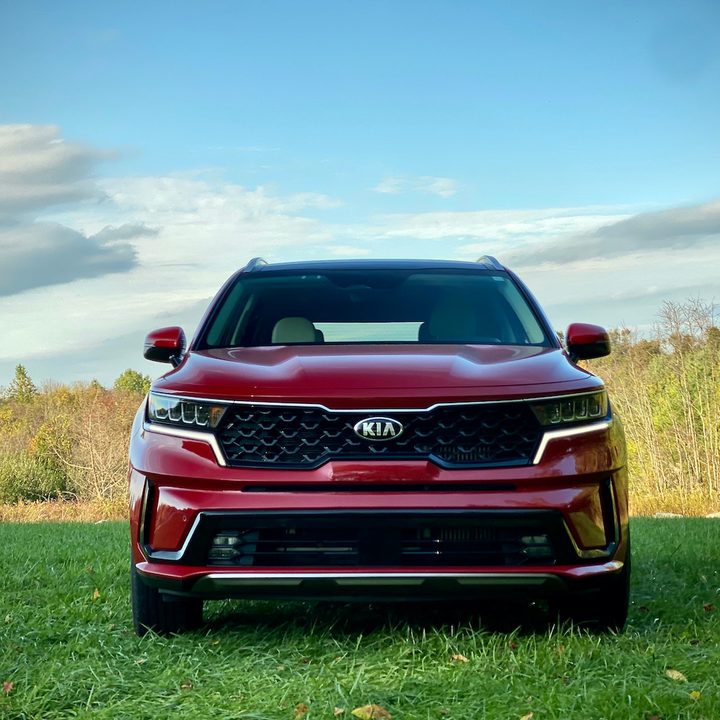 Front end close up of the 2021 Kia Sorento Hybrid in a grassy field.