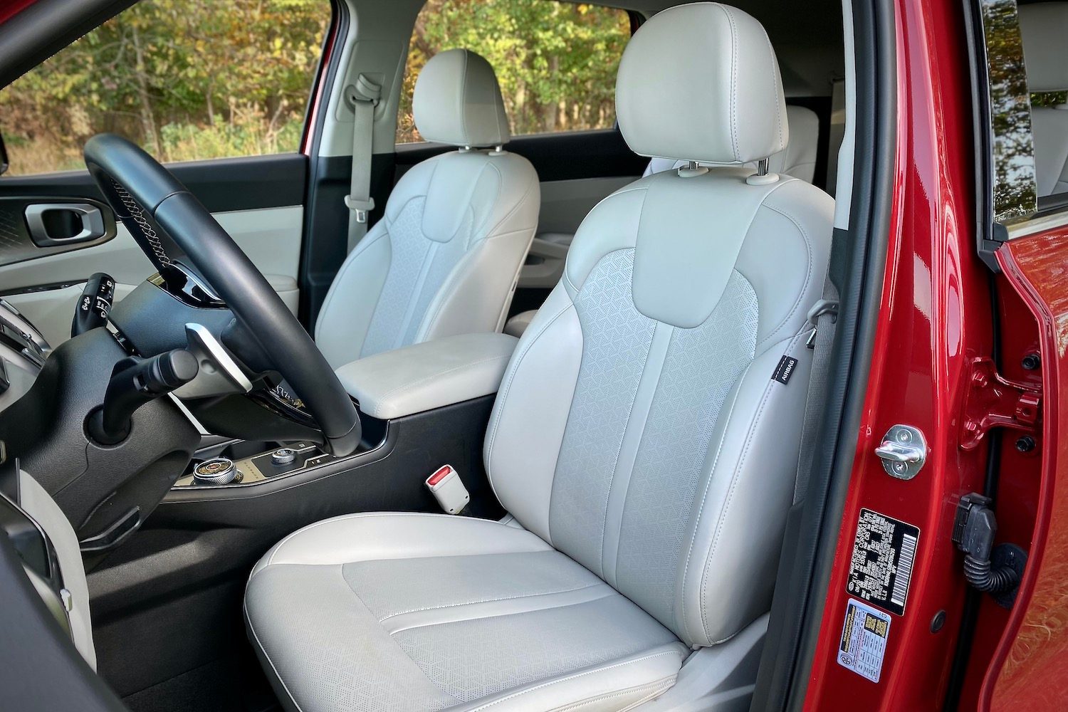 Driver's seat in the 2021 Kia Sorento Hybrid with trees in the background.