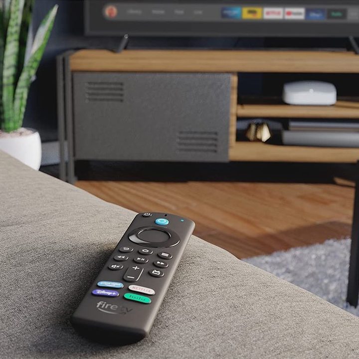 Amazon Fire TV Stick 4K Max remote on a couch arm.