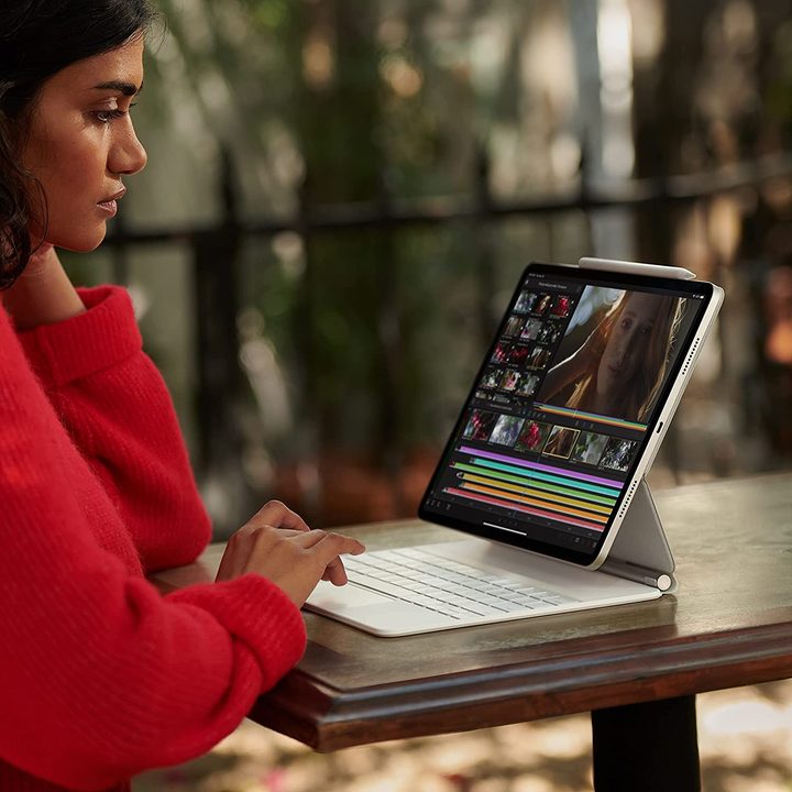 A woman typing on an 11-inch Apple iPad Pro (2021) with keyboard attachment.