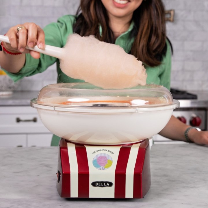 Bella Cotton Candy Maker with woman using cone to serve.