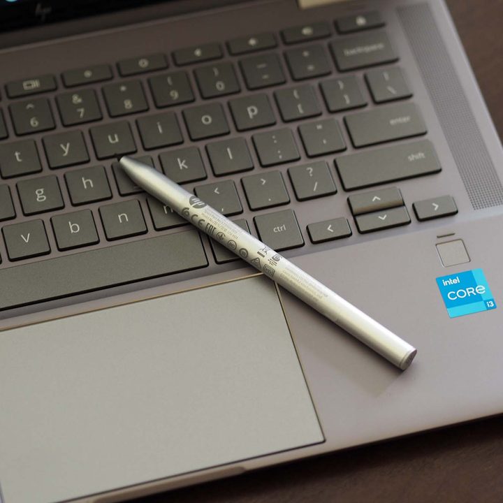Closeup on the HP Chromebook x360 14c's keyboard, trackpad, and stylus.