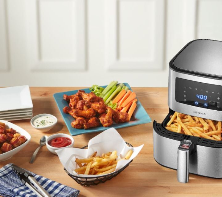 The Insignia 5-qt Digital Air Fryer alongside plates filled with food.
