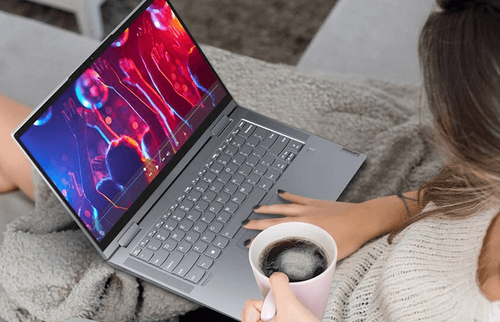 A woman working on her Yoga 7i 2-in-1 laptop.