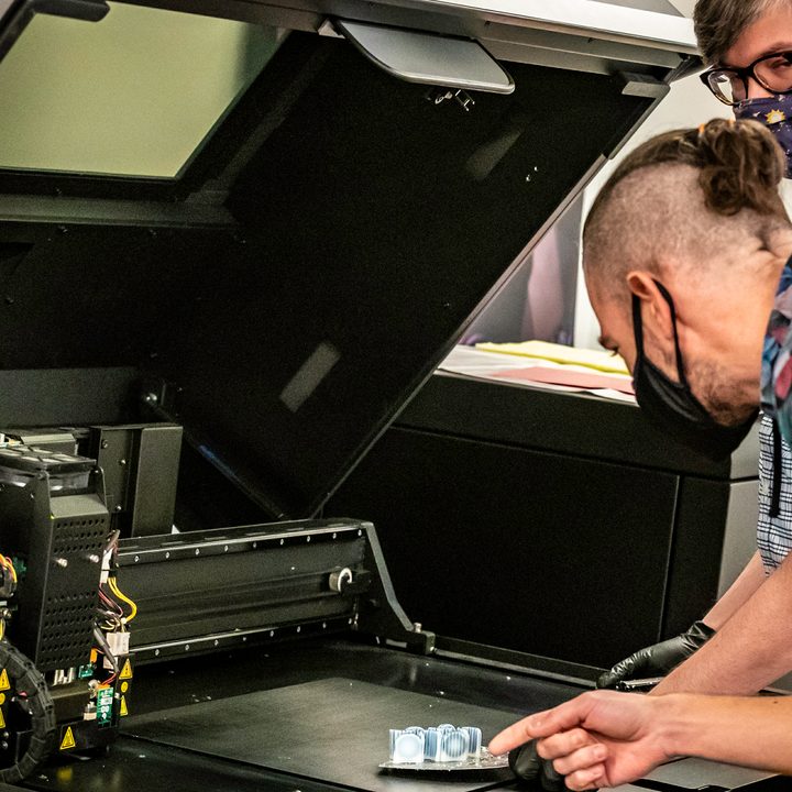 Image of Motorola 312 Lab’s employees review a 3D printed component.