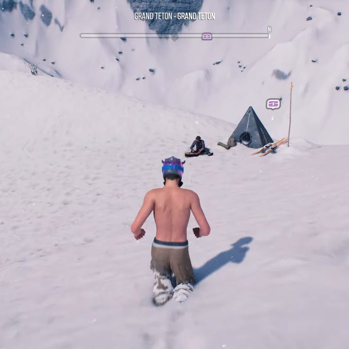 A shirtless man running to a snowy camp.