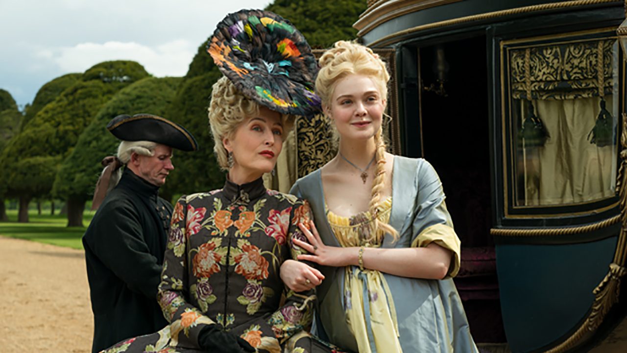 Elle Fanning as Catherine the Great and Gillian Anderson as her mother linking arms in a scene from The Great.