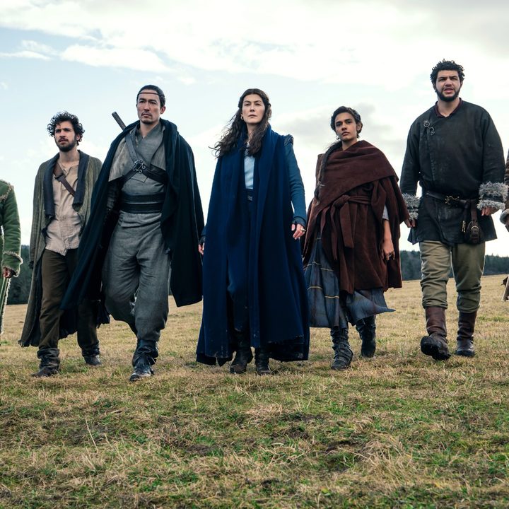 The cast of Amazon Studios' The Wheel of Time marches across a field.