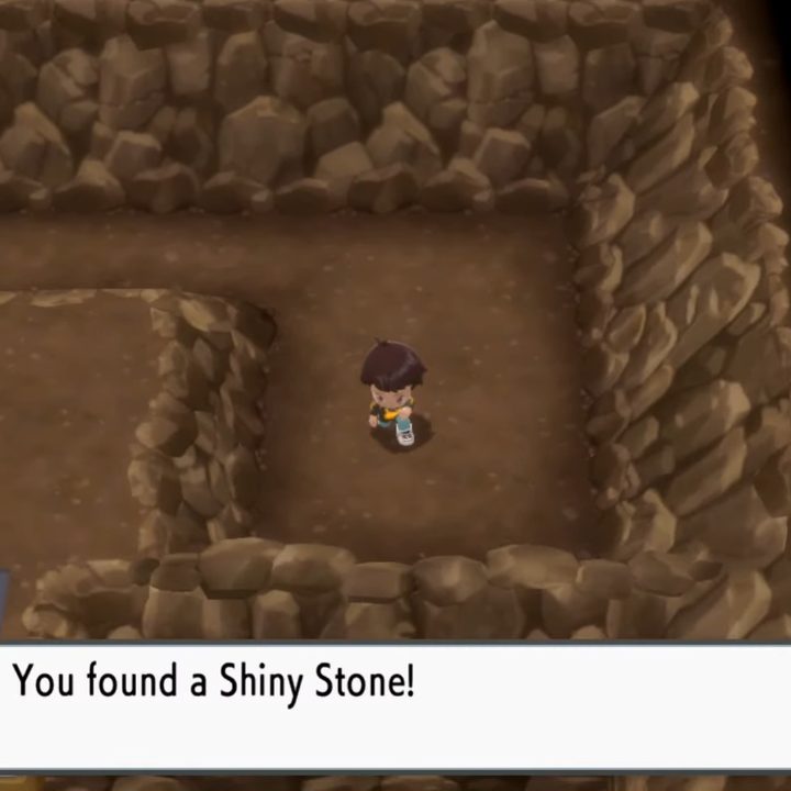 Picking up a shiny stone in a cave,
