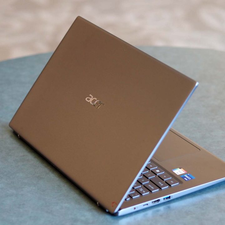 An Acer Swift 3 16 laptop sits on a desk showing its backside, angled to the right.