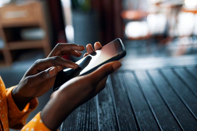 DocuSign woman using phone to sign document in cafe.